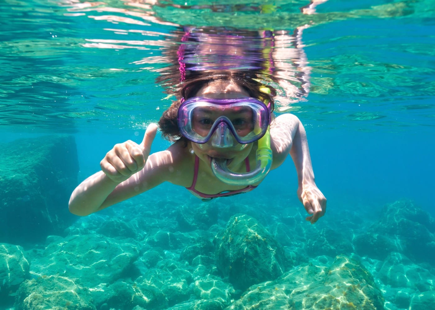 a girl snorkelling in the ocean - Bali weather in June is perfect for water sports