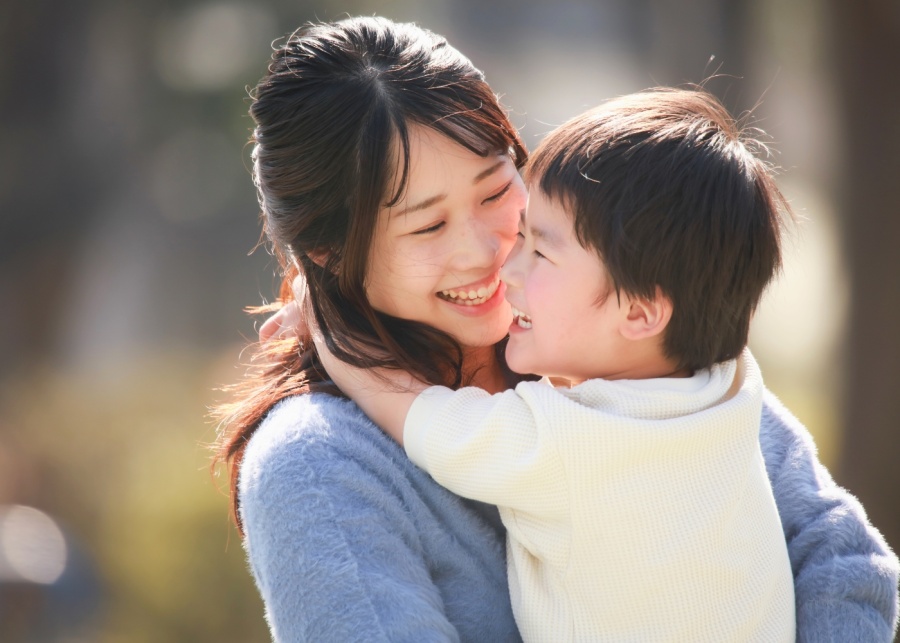 mother holding a kid while smiling