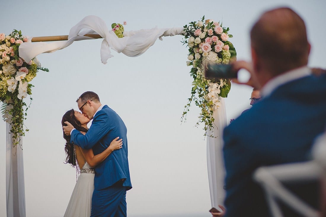 Newly-wed couple kissing | Real wedding: Julie and Toby's breezy, cliff-top villa wedding in Bali